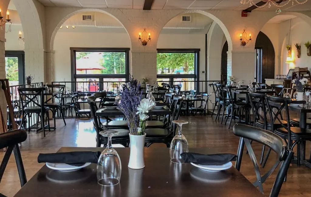 Set tables under white arches at Appalachia Kitchen, looking toward the deck