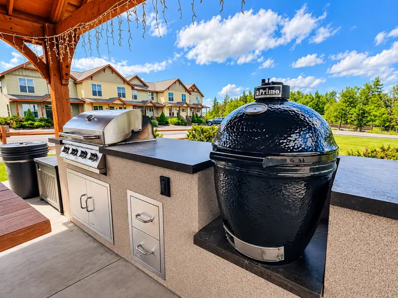 Outdoor kitchen at the Black Bear Crossing pavilion with a gas grill and a ceramic smoker