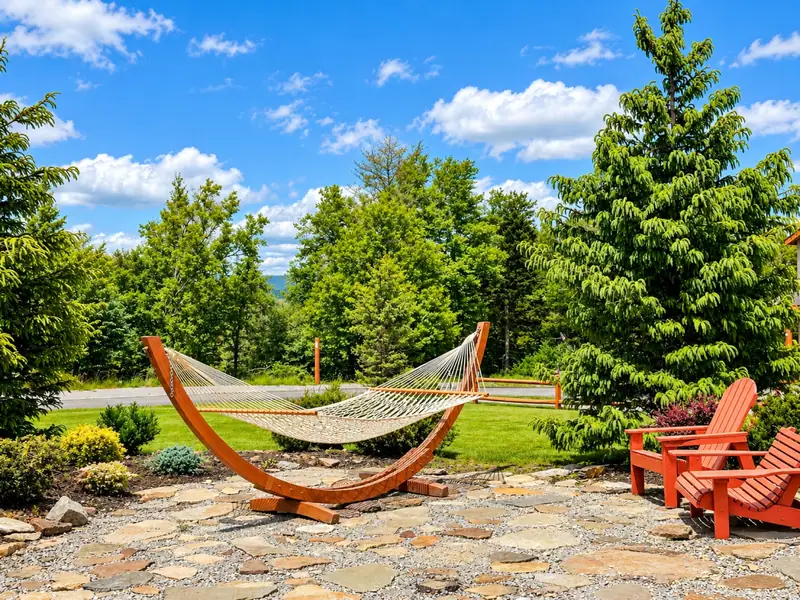 Hammock and red Adirondack chairs on the stone patio at Black Bear Crossing