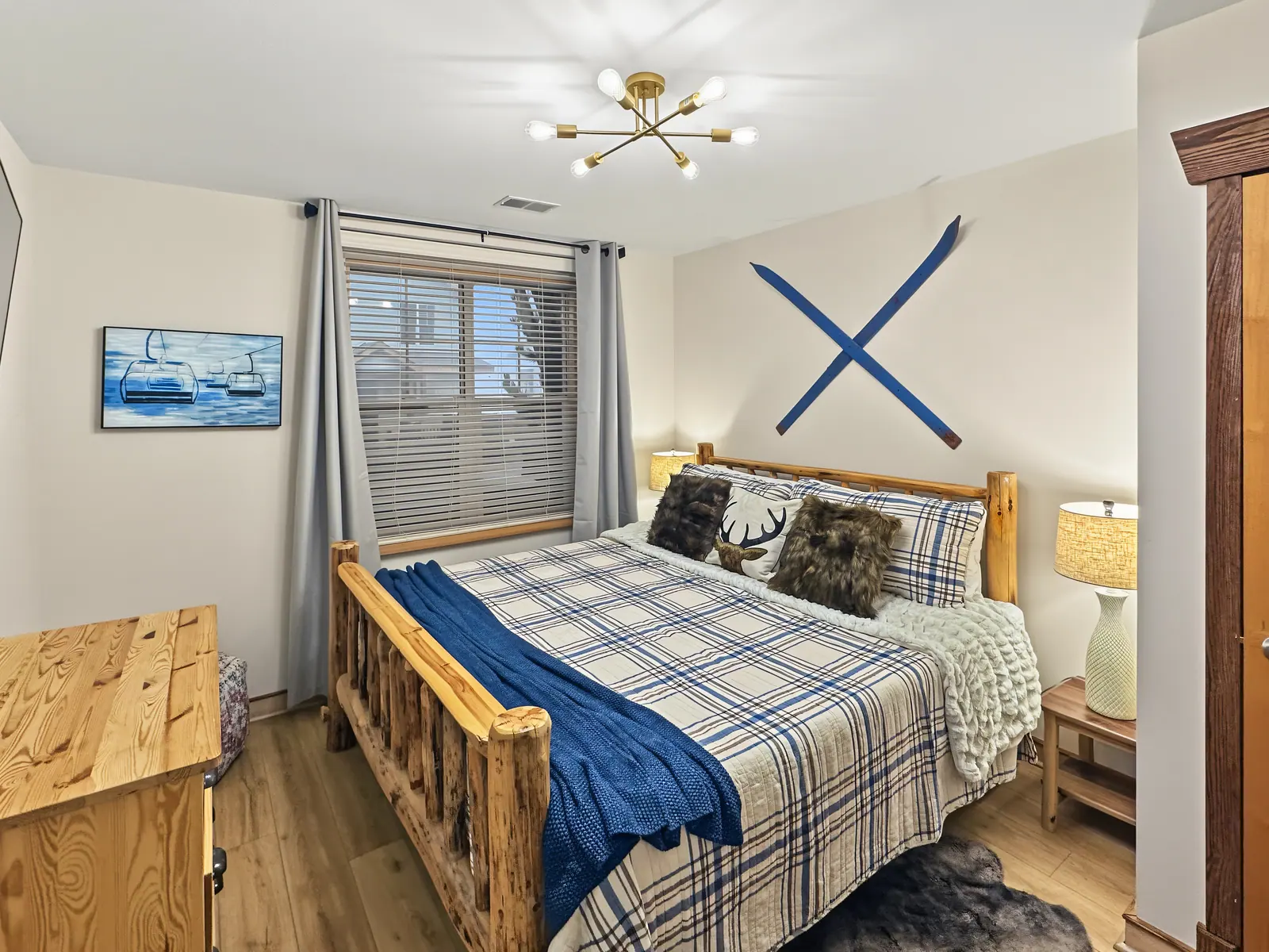 King bedroom at Black Bear 33 with a log bed frame and plaid quilt