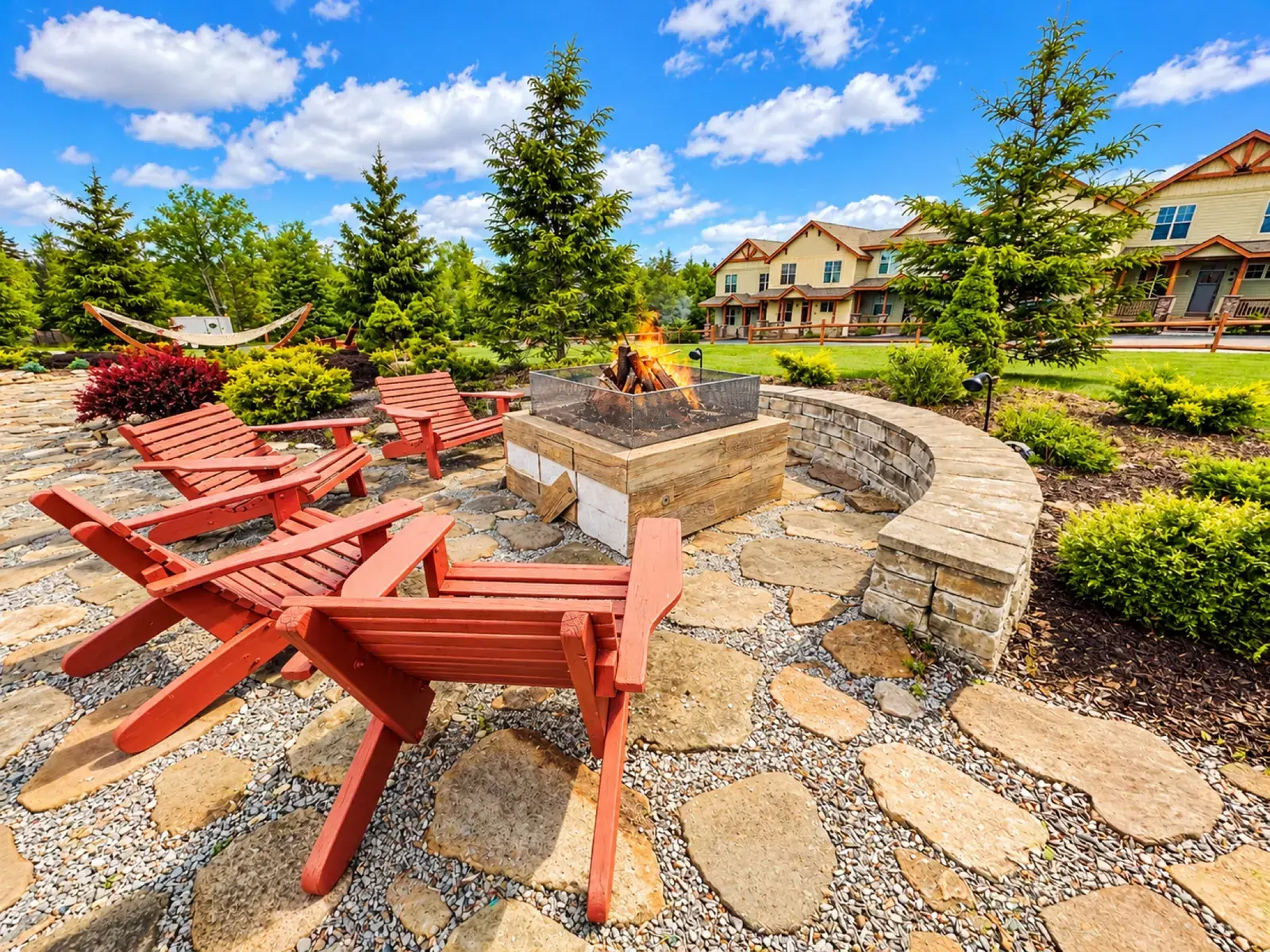 Adirondack chairs around the gas fire pit beside the pavilion