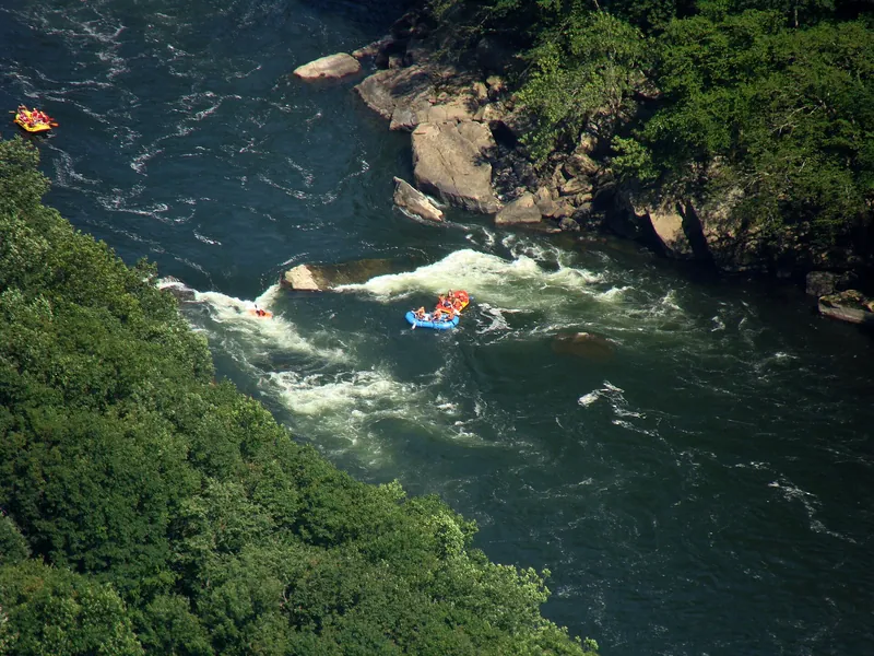 Rafts running whitewater on the New River, seen from high above in the gorge