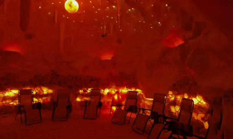 The salt cave at Pomona Salt Cave and Spa, glowing orange with lounge chairs and hanging lights