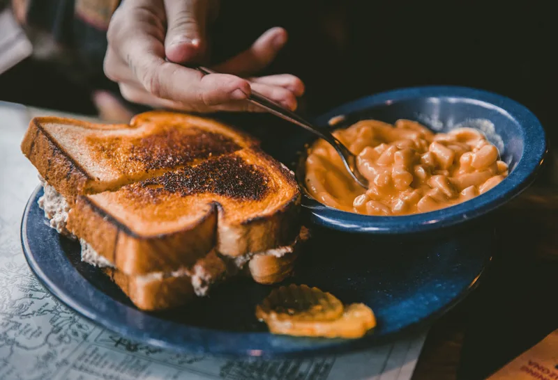 A grilled cheese sandwich next to a bowl of tomato soup