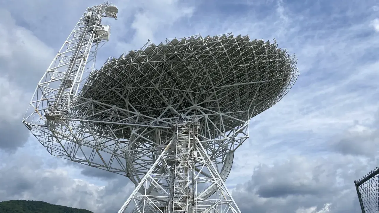 The Green Bank Telescope seen from below, filling the frame against a cloudy sky