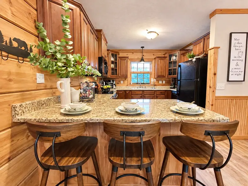 Granite island with bar stools in the Loggers Run 12 kitchen