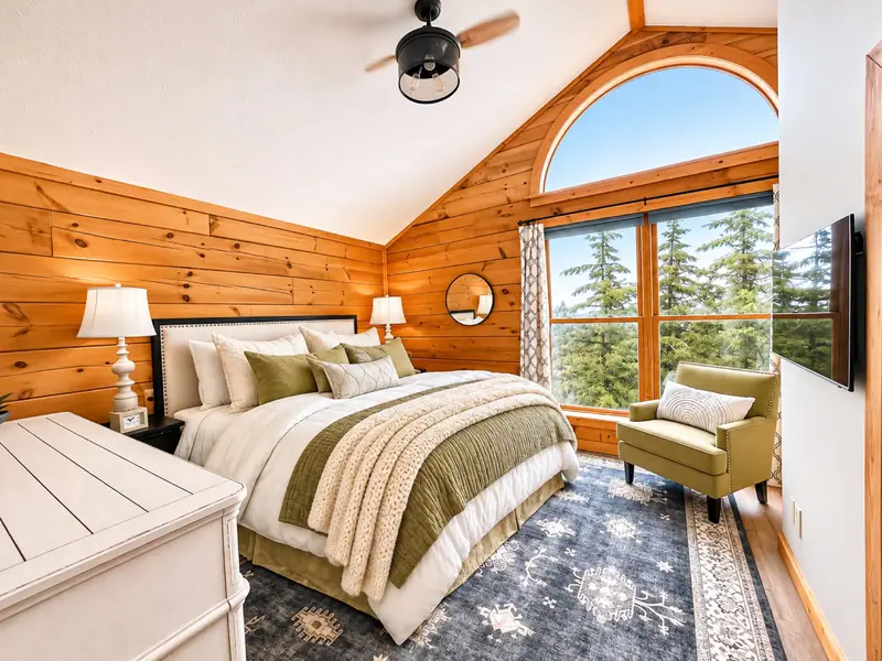 King primary suite at Loggers Run 12 with an arched window and a reading chair