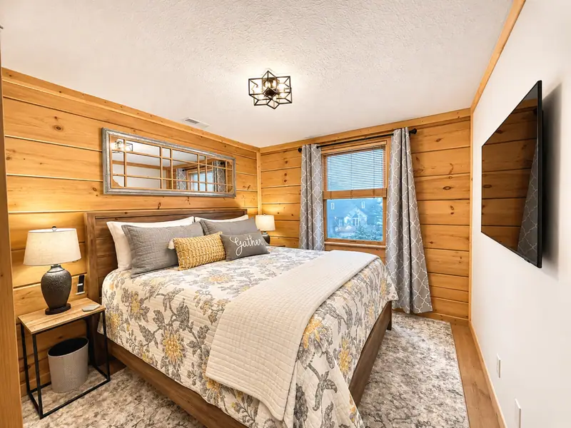 King bedroom at Loggers Run 12 with knotty pine walls and a wall TV