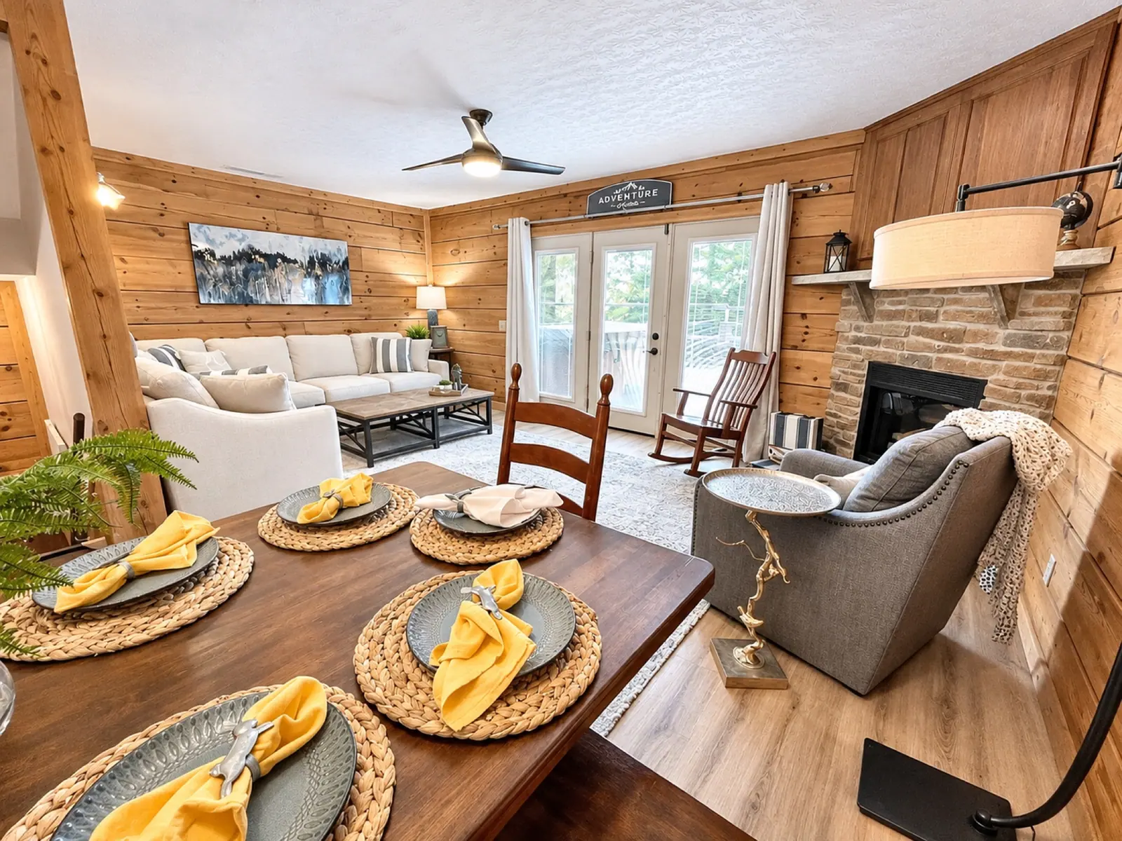 Dining table set for a meal at Loggers Run 12, with the sectional and gas fireplace beyond