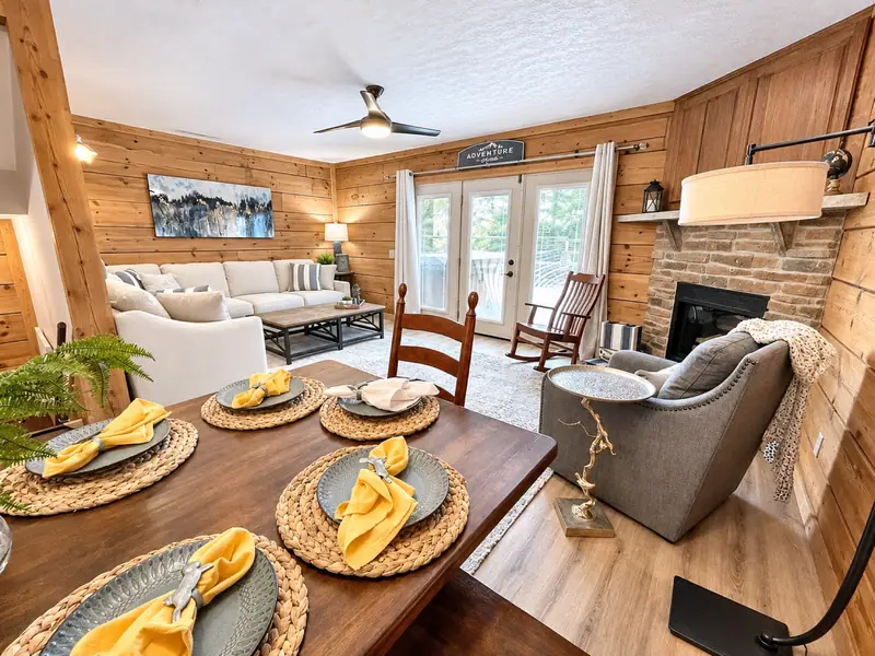 Dining table set for a meal at Loggers Run 12, with the sectional and gas fireplace beyond