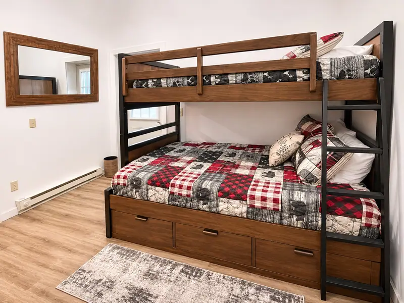 Bunk bed with a trundle and red plaid bedding in a Loggers Run 12 bedroom