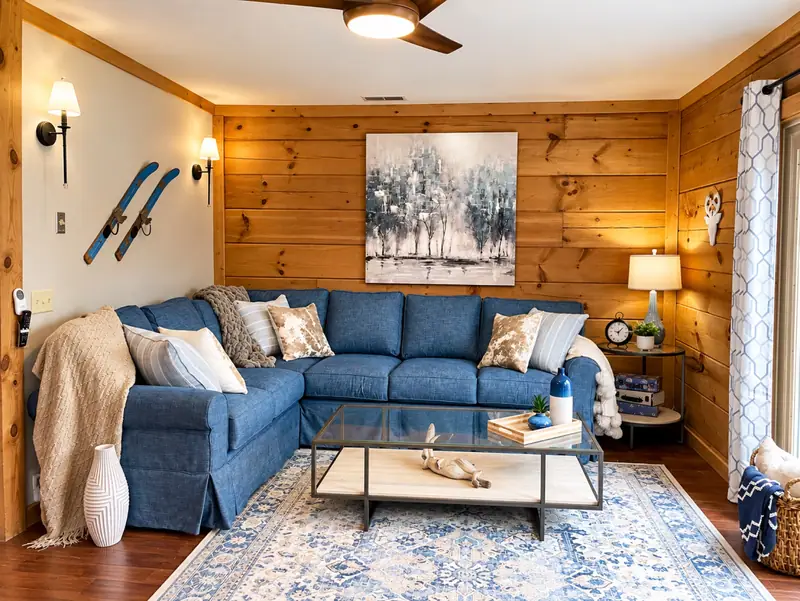 Living room at Loggers Run 16 with a blue sectional and crossed skis