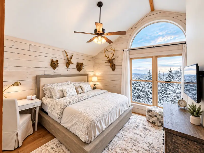 Primary bedroom at Loggers Run 16 with an arched window over the mountains