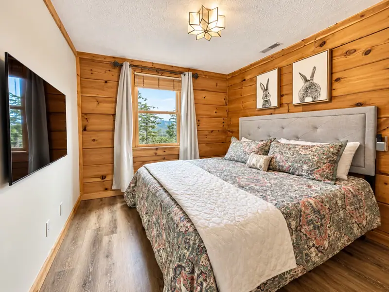 King bedroom at Loggers Run 16 with knotty pine walls and rabbit prints