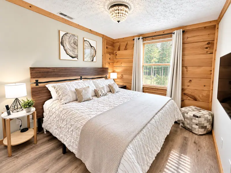 King bedroom at Loggers Run 16 with white bedding and a wall TV