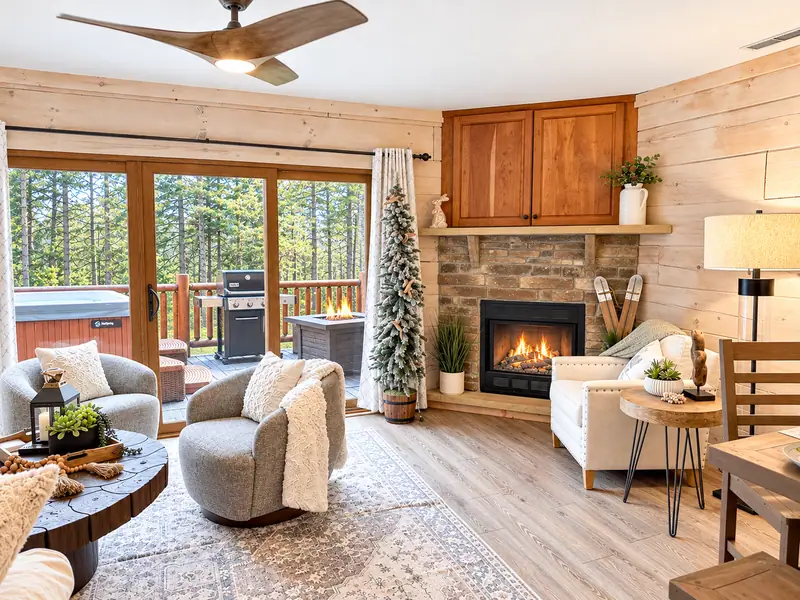 Living area at Loggers Run 4 with swivel chairs, a stone gas fireplace and sliding doors to the deck