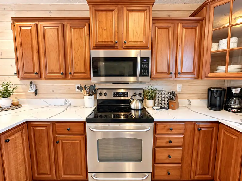 Kitchen at Loggers Run 4 with cherry cabinets, granite counters and a stainless range