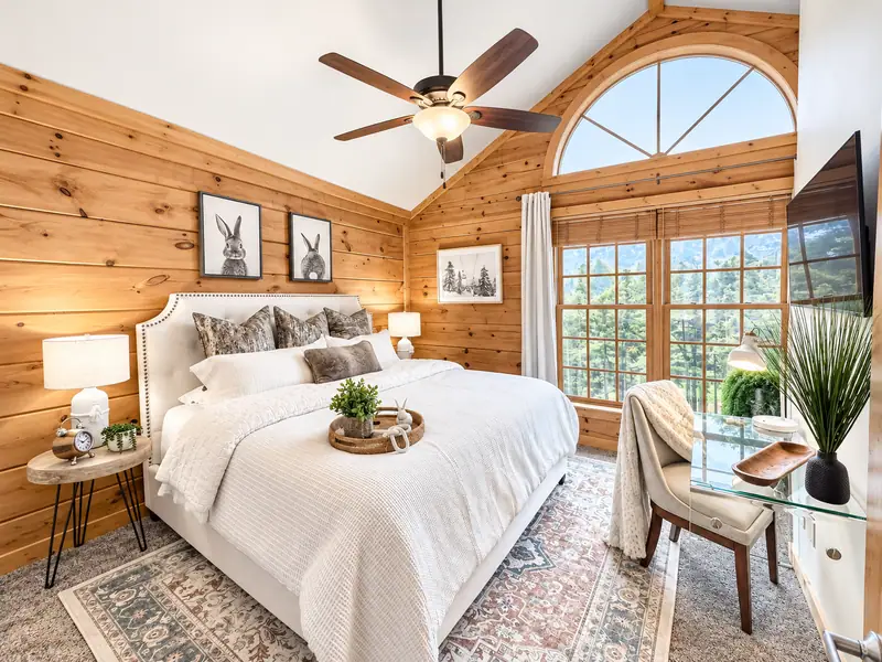 Primary bedroom at Loggers Run 4 with a king bed, ceiling fan and arched window
