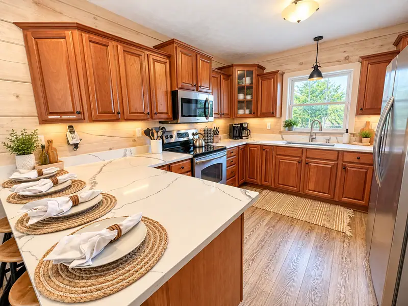 Kitchen at Loggers Run 4 with a white island, cherry cabinets and a window over the counter