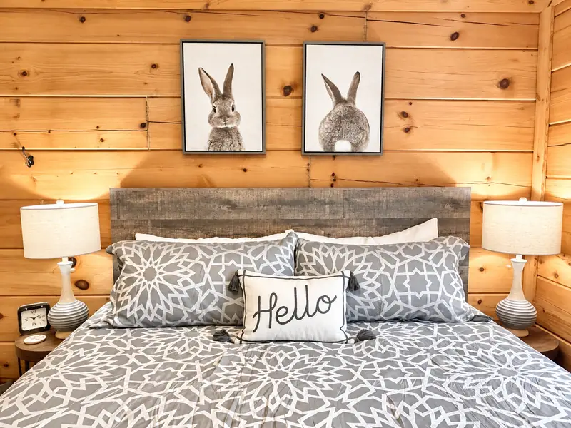 King bed at Loggers Run 4 with a reclaimed wood headboard and two rabbit prints