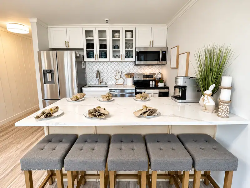 White kitchen at Mountain Lodge 114 with a breakfast bar and gray stools