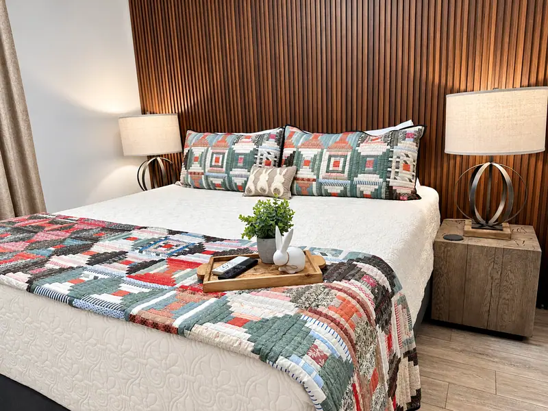 Bedroom at Mountain Lodge 114 with a wood slat accent wall and patchwork quilt