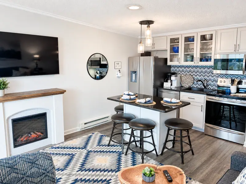Living room at Mountain Lodge 140 with an electric fireplace, TV and kitchen island behind