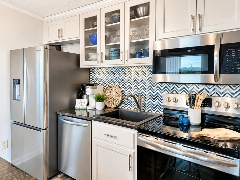 Kitchen at Mountain Lodge 140 with a stainless fridge, range and blue chevron backsplash