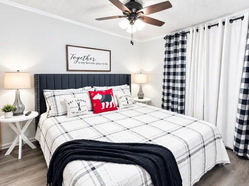 Bedroom at Mountain Lodge 140 with plaid bedding and a ceiling fan