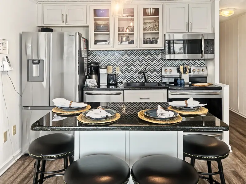 Renovated kitchen at Mountain Lodge 140 with stainless appliances and island seating for four