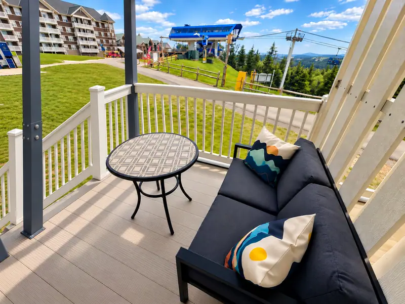 Balcony at Mountain Lodge 140 with a sofa and view of the Ballhooter lift in summer