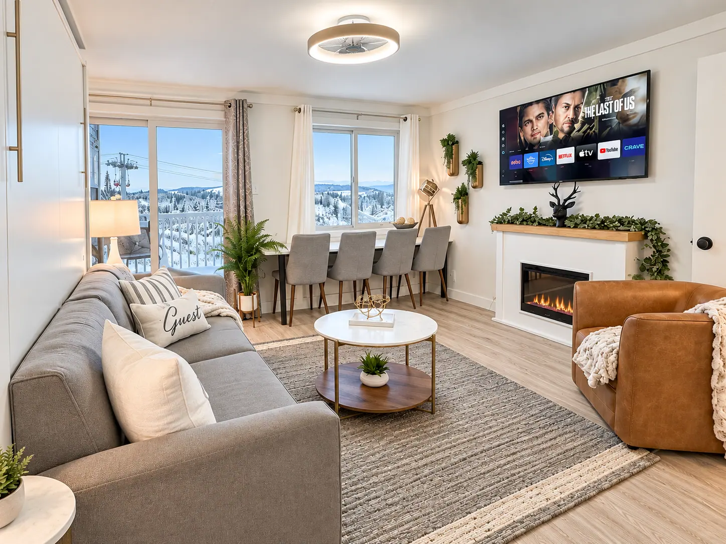 Living room at Mountain Lodge 144 with a gray sofa, dining table, and electric fireplace