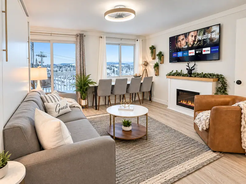 Living room at Mountain Lodge 144 with a gray sofa, dining table and electric fireplace