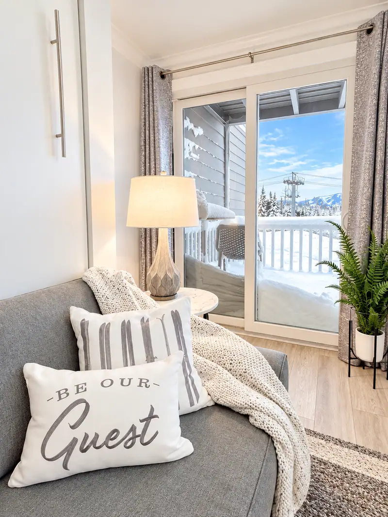 Sofa with a Guest pillow beside the balcony door at Mountain Lodge 144