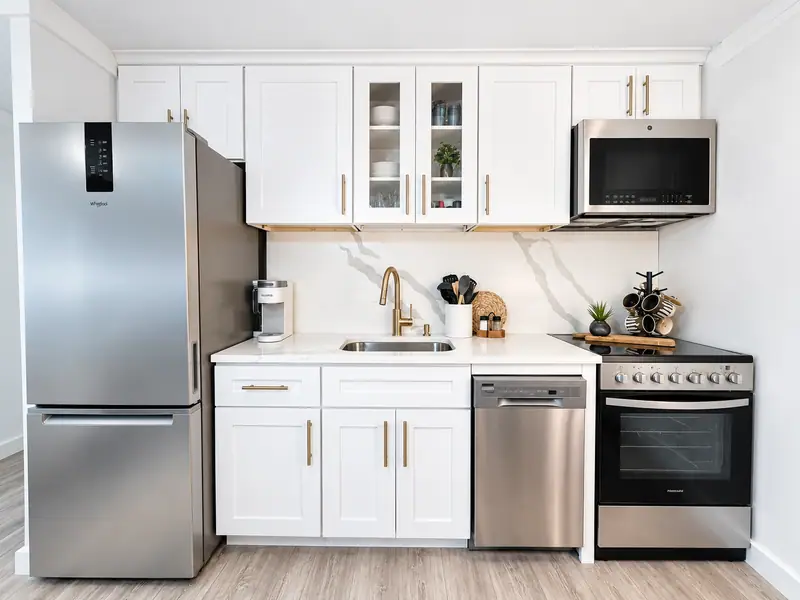 White kitchen at Mountain Lodge 144 with a stainless fridge and range