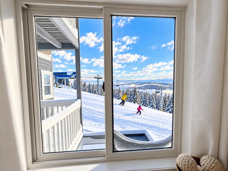 Sliding door at Mountain Lodge 144 looking out at skiers on the slope