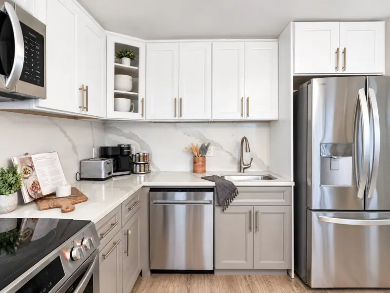 White kitchen at Mountain Lodge 146 with a stainless fridge and gray lower cabinets