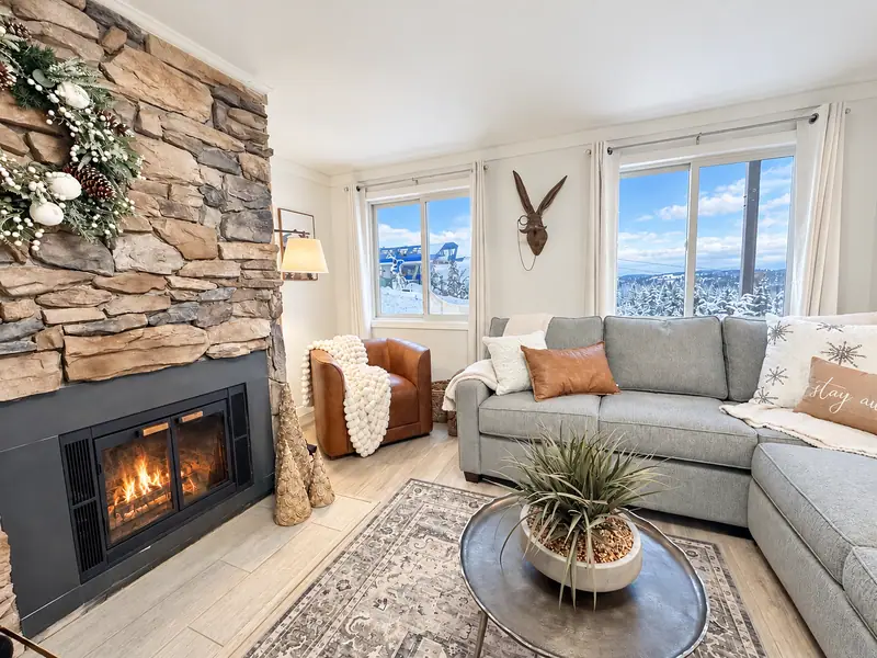 Stone fireplace and gray sectional at Mountain Lodge 146