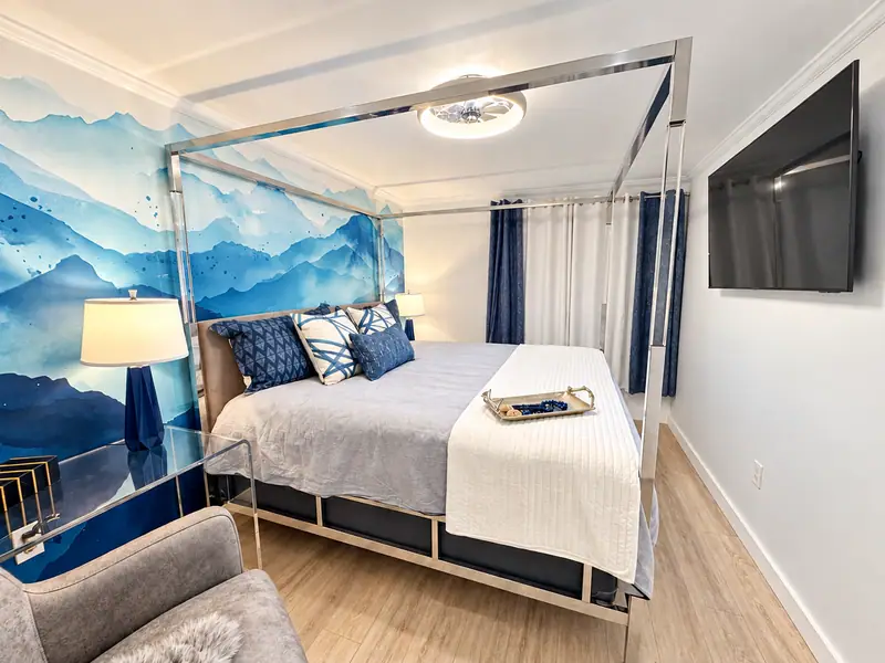 Canopy bed and wall TV in the Mountain Lodge 146 primary bedroom