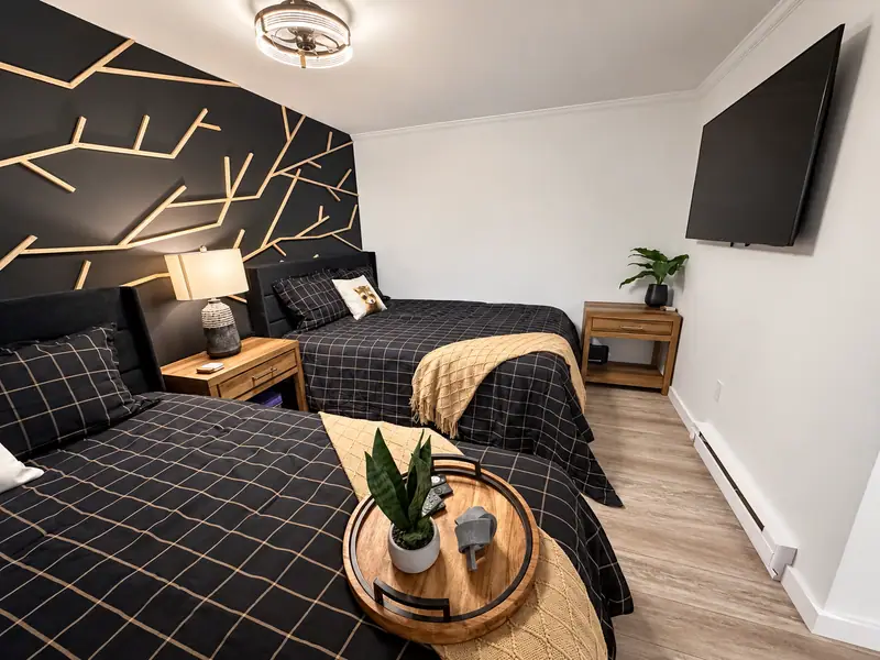 Two queen beds and a wall TV at Mountain Lodge 146