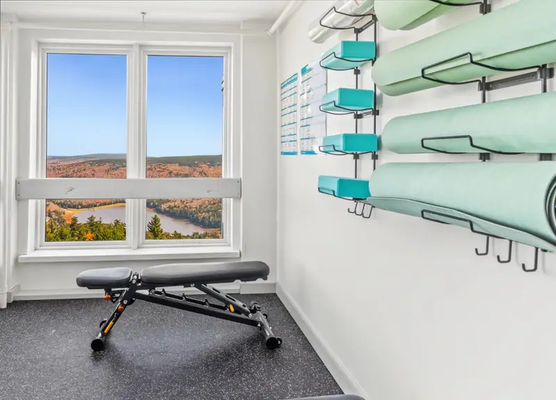 Weight bench in the Mountain Lodge fitness room with a window view of fall foliage