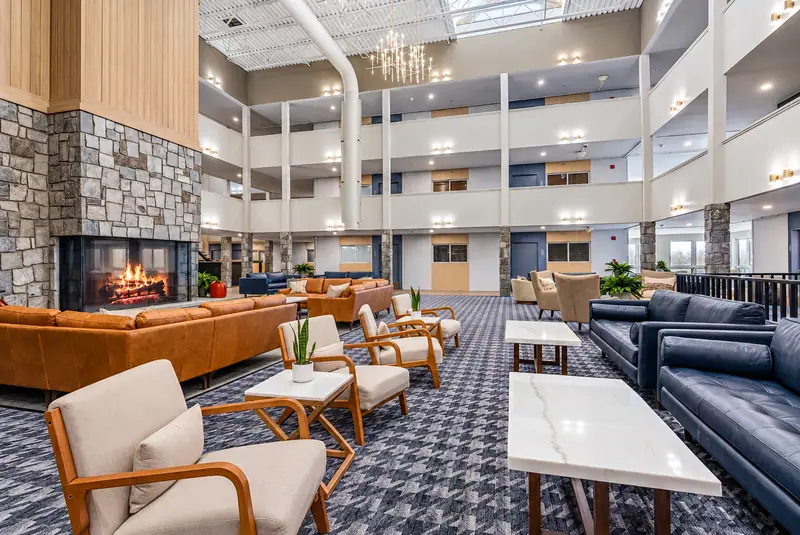 Mountain Lodge lobby with a stone fireplace, leather sofas and the open atrium above