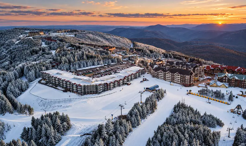 Aerial view of Mountain Lodge and the snowy slopes at sunset