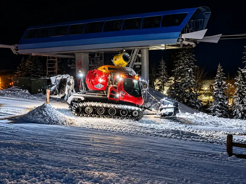A snowcat beneath the lift terminal at night