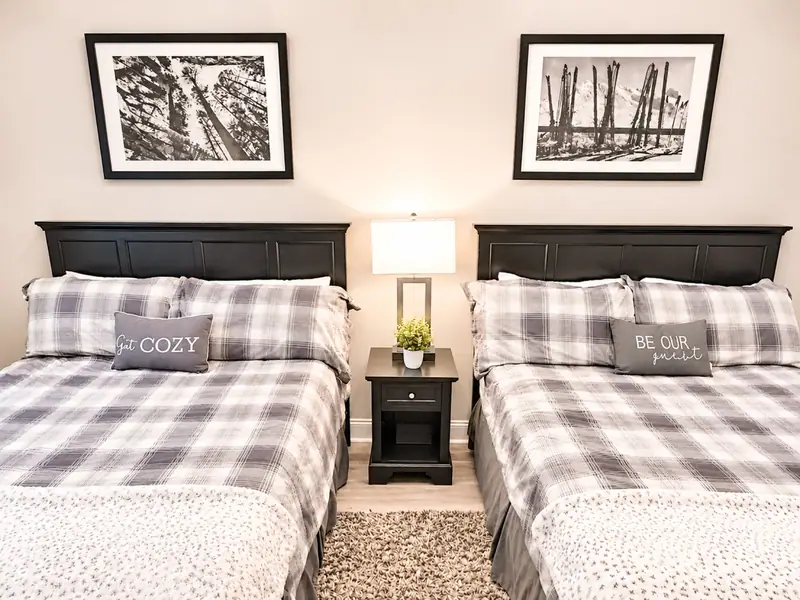 Two beds with plaid bedding and black-and-white tree prints at Seneca 113